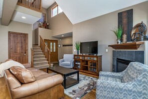 Relax in this inviting living room with a fireplace, flat-screen TV, and comfortable seating areas.