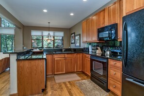 Enjoy cooking in this well-equipped kitchen with a central island, sink, and modern appliances.