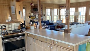 Une cuisine spacieuse avec des meubles en bois, un grand îlot central et un four encastré.