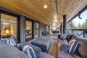 A modern interior with a wooden ceiling, large windows, and a cozy seating area with patterned cushions. - Pinnacle Ridge 3 - Ski in Ski out, 7 Bedrooms, Hot Tub, Sauna & Billiards (Whistler)