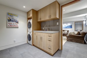 A compact kitchen with wooden cabinets, a built-in washing machine, and a countertop with a sink.