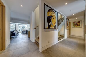 A modern interior with a staircase, artwork, and a view to a living area. - Pinnacle Ridge 3 - Ski in Ski out, 7 Bedrooms, Hot Tub, Sauna & Billiards (Whistler)