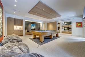 A modern living room with a pool table, a sofa, and a large painting. - Pinnacle Ridge 3 - Ski in Ski out, 7 Bedrooms, Hot Tub, Sauna & Billiards (Whistler)