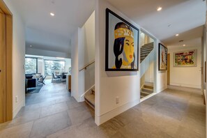 A modern interior with a staircase, a living area with a sofa and coffee table, and artwork on the walls. - Pinnacle Ridge 3 - Ski in Ski out, 7 Bedrooms, Hot Tub, Sauna & Billiards (Whistler)