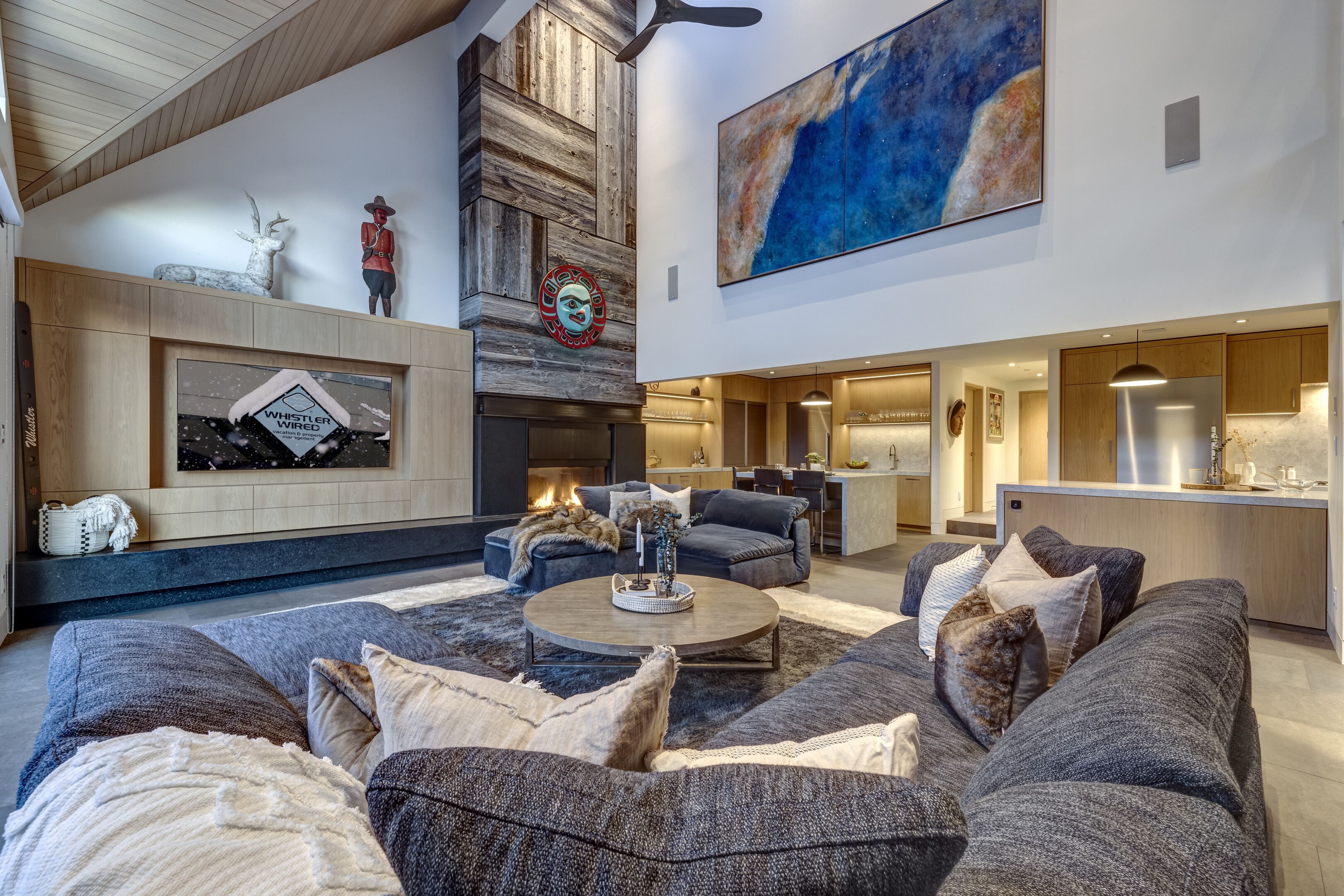Ein modernes Wohnzimmer mit Kamin, Sofas und einem Essbereich.
