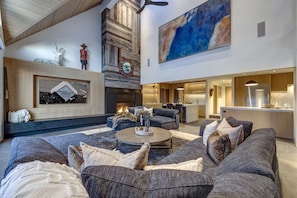 A modern living room with a fireplace, sofas, and a dining area. - Pinnacle Ridge 3 - Ski in Ski out, 7 Bedrooms, Hot Tub, Sauna & Billiards (Whistler)