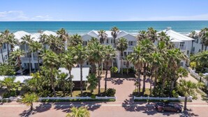 A beachfront hotel with multiple-story buildings, palm trees, and a view of the ocean. - Manu Kai - Beachfront House With Private Pool And Hot Tub 6 Bedroom Home by RedAwning (South Padre Island)