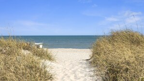 A sandy beach path leading to the sea, surrounded by tall grass. - Sea Colony 2A | Oceanfront, Private Beach Walkway (Carolina Beach)