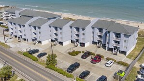 A beachfront hotel with multiple balconies, parking, and a view of the ocean. - Sea Colony 2A | Oceanfront, Private Beach Walkway (Carolina Beach)