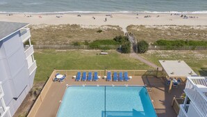A pool area with lounge chairs and a view of the beach. - Sea Colony 2A | Oceanfront, Private Beach Walkway (Carolina Beach)