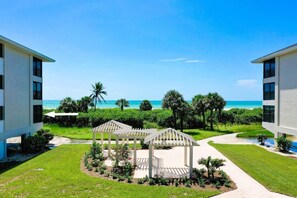 Um resort com vista para a praia, dois edifícios brancos e um coreto no centro.