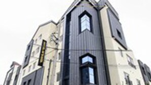 Un edificio moderno con un diseño angular distintivo, con varios niveles y una entrada destacada.