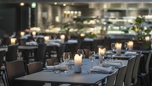 A restaurant with tables set for dining, candles, and a modern interior. - Hotel Kazerne (Eindhoven)