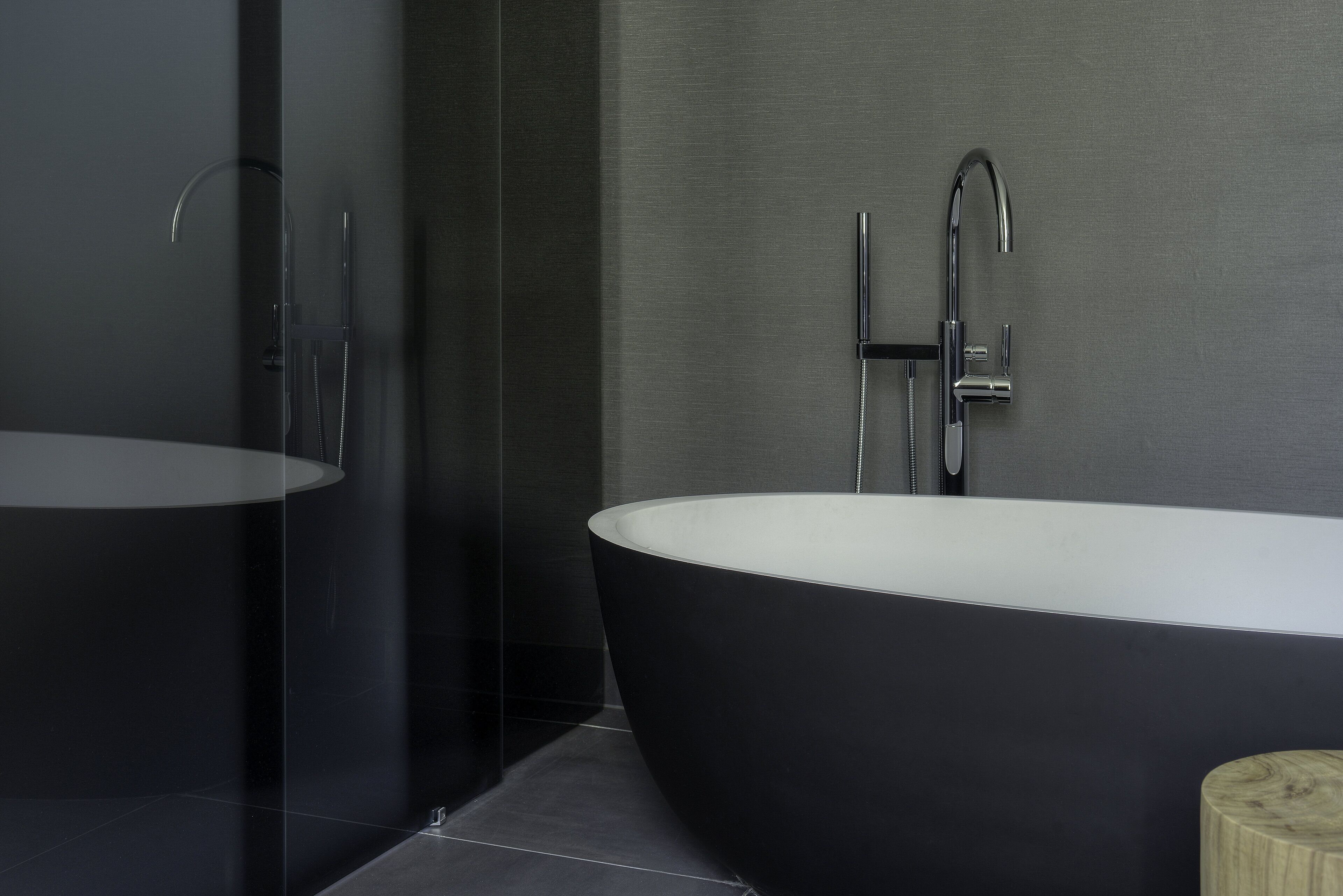 A modern bathroom with a freestanding bathtub, a glass-enclosed shower, and a large mirror.