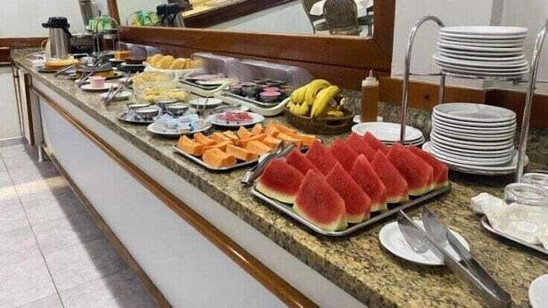 Mostrador de buffet con diversos alimentos y utensilios.