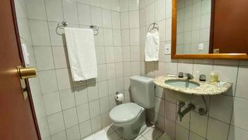 Et lille badeværelse med toilet, vask og spejl.