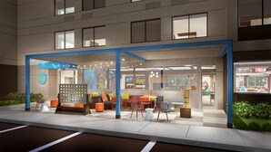 A hotel lobby with seating areas, a reception desk, and a visible restaurant counter. - Tru by Hilton Audubon Valley Forge (Audubon)