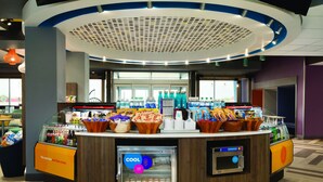 A food display area with various snacks and a refrigerated section labeled "COOL". - Tru by Hilton Audubon Valley Forge (Audubon)