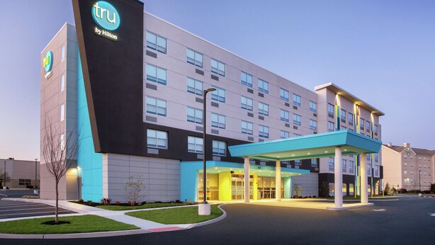 A modern hotel with a prominent 'tru by Hilton' sign, a covered entrance, and a parking lot. - Tru by Hilton Audubon Valley Forge (Audubon)