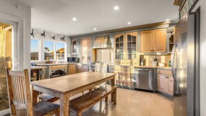 Eine geräumige Küche mit Holdekor, einem Edelstahlkühlschrank und einem Essbereich mit Holztisch und Stühlen.