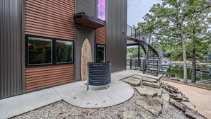 Un edificio moderno con fachada de madera, una escalera espiral y vistas a un lago.