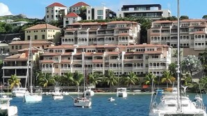Un port de plaisance où sont amarrés de nombreux bateaux, entouré d’immeubles à plusieurs étages dotés de balcons.