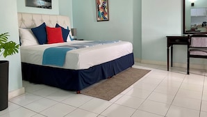 Une chambre bien rangée, avec un lit, une table de chevet, un bureau et une chaise.