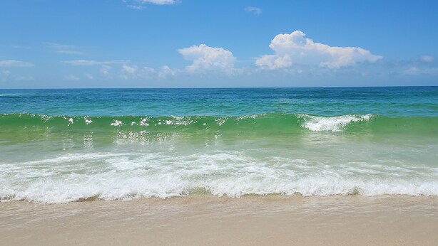 Una playa con aguas turquesas cristalinas y olas suaves.