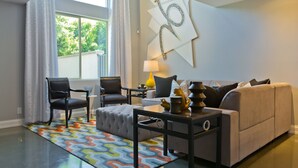 A living room with a sofa, two chairs, a coffee table, and a rug. - Designer Townhouse in the heart of Palm Springs, Convention Center. CITY ID#3867 (Palm Springs)