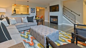 A modern living room with a grey sofa, ottoman, and patterned rug. - Designer Townhouse in the heart of Palm Springs, Convention Center. CITY ID#3867 (Palm Springs)