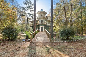 A wooden bridge leading to a multi-level house surrounded by trees. - Breathtaking, Wooded River Retreat " Isle Of View" (Folsom)