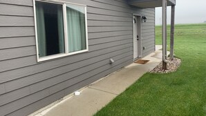 A gray house with a window, door, and a small porch area.