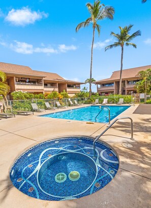 A pool area with lounge chairs, a hot tub, palm trees, and a building with a sign that reads "Oregon".