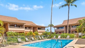 A pool area with lounge chairs, a hot tub, palm trees, and a building with a sign that reads "Oregon". - Where Serenity Awaits Kihei Spacious Condo Private Lanai Pool Near Beach (Kihei)