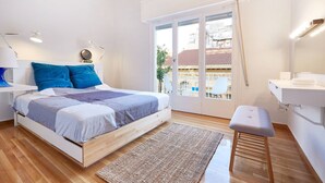 Un dormitorio moderno con cama, mesita de noche y vistas al balcón.