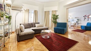 Una sala de estar moderna con un sofá, sillones, una mesa de centro y una alfombra roja.