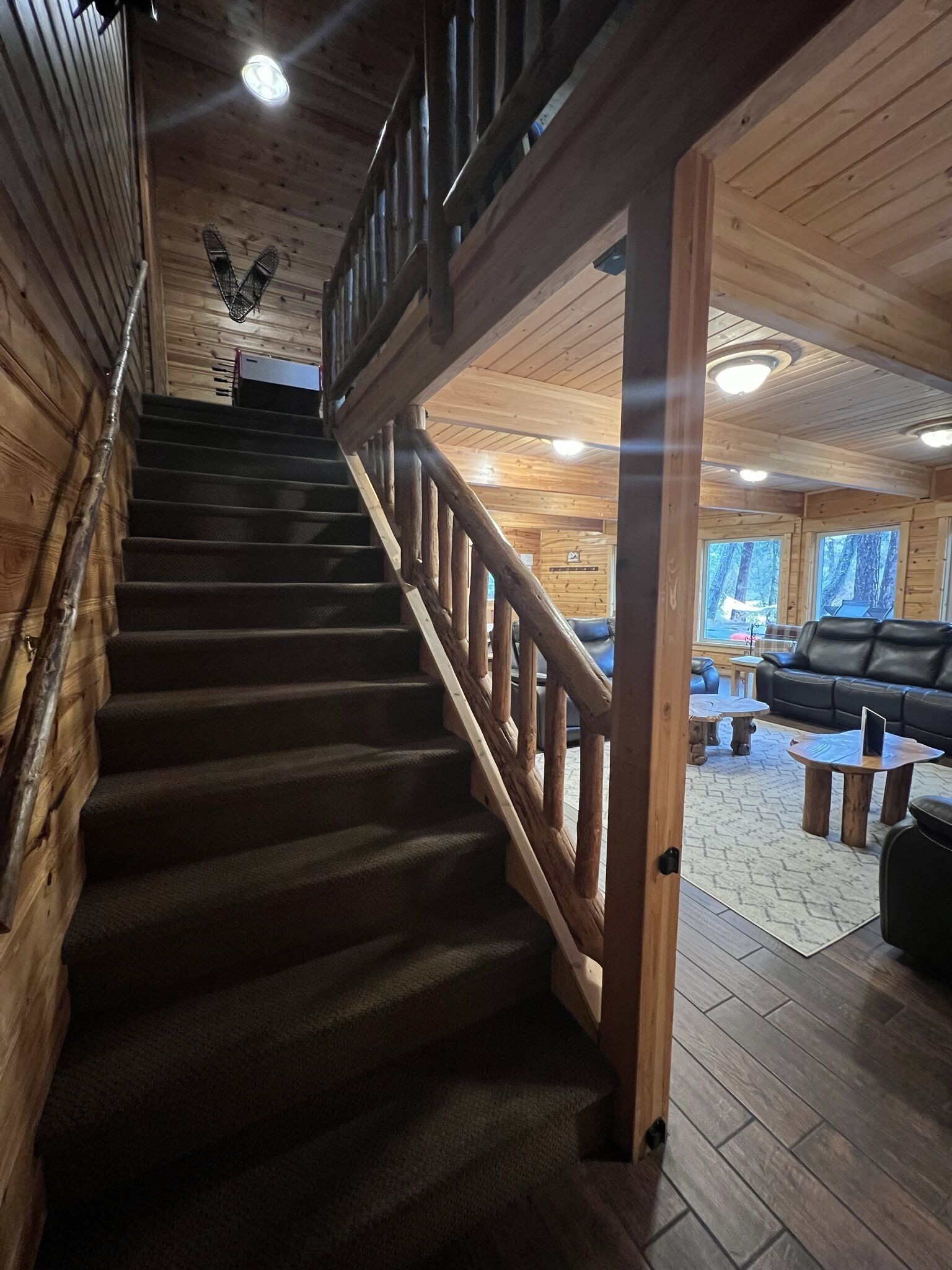 A wooden staircase with a handrail leading to a second floor.