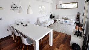 A modern, minimalist living space with a white dining table, two white chairs, a white sofa, and a white coffee table. - Magnificent Villa with private pool (Almuñécar)
