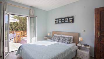 A bedroom with a bed, a nightstand, a wall-mounted shelf, and a sliding glass door leading to an outdoor area.