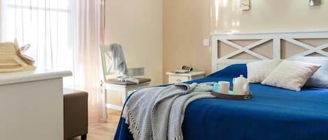 A hotel room with a bed, bedside table, lamp, and a chair.