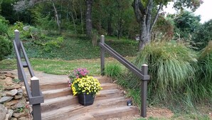 A wooden staircase with a black metal handrail leading to a grassy area. - Afton Station Cottage -Beautifully Renovated Blue Ridge Scenic Historic Setting (Afton)