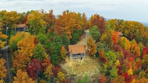 A cabin surrounded by autumn foliage with a dirt path leading to it. - CJ's Cabin: A Secluded 1-Bedroom Retreat with Mountain Views and Hot Tub (Sieverville)