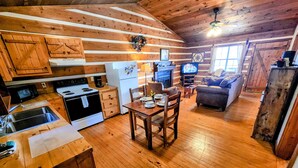 A rustic cabin interior with a kitchen, dining area, and living room. - CJ's Cabin: A Secluded 1-Bedroom Retreat with Mountain Views and Hot Tub (Sieverville)