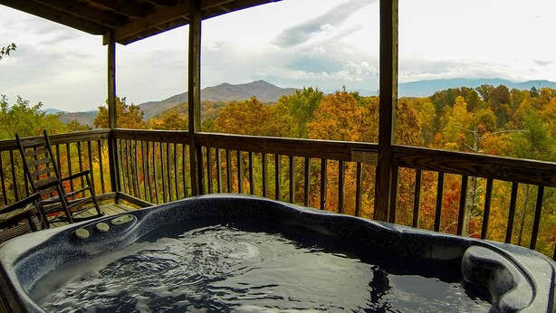 A hot tub on a wooden deck with a view of autumn trees and mountains. - CJ's Cabin: A Secluded 1-Bedroom Retreat with Mountain Views and Hot Tub (Sieverville)