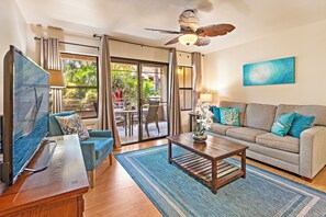 A living room with a sofa, coffee table, and a painting on the wall. - Charming Kihei Condo Private Lanai Pool Hot Tub Steps to Whale Sanctuary (Kihei)