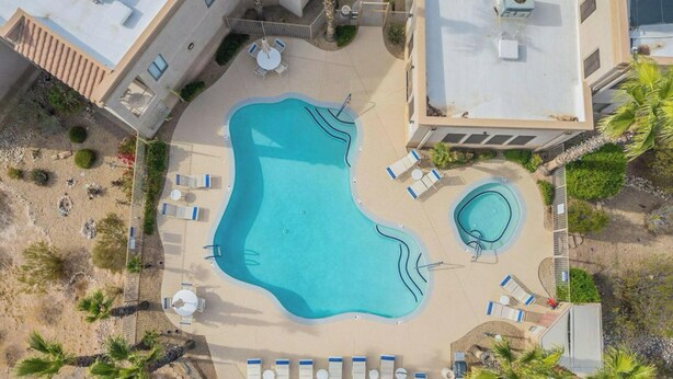 Luftaufnahme eines Poolbereichs mit Liegestühlen und einem kleineren Pool.