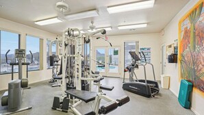 Ein Fitnessstudio mit Cardiogeräten, Krafttrainingsgeräten und einem Wandgemälde.