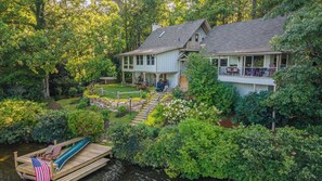 Une maison à deux étages avec une terrasse et un quai pour bateaux.