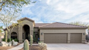 A residential building with a garage, a driveway, and a landscaped garden with cacti. - The Best Of Ahwatukee (Phoenix)