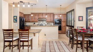 A spacious kitchen with wooden cabinets, a central island, and pendant lighting. - The Best Of Ahwatukee (Phoenix)